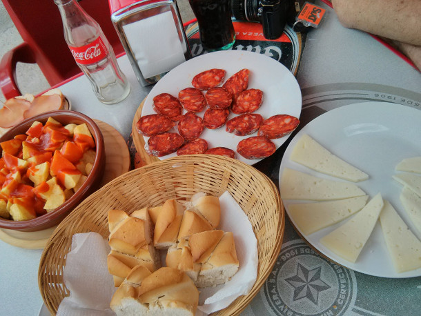 Raciones (portions) of chorizo, manchego cheese, patatas bravas, and the customary side of bread